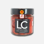 Tarro de pimientos del piquillo en conserva, con etiqueta negra y logo de la marca LC, ideal para añadir sabor a platos españoles.