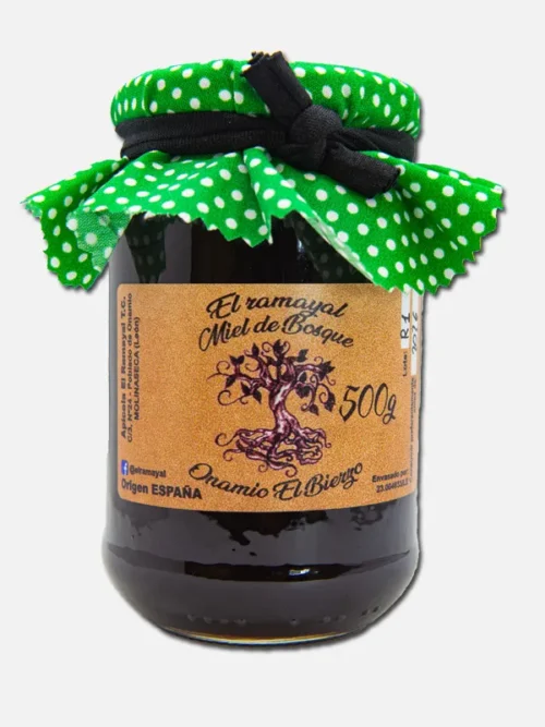 Tarro de mermelada artesanal con tapa de tela verde con puntos blancos, etiquetado con el nombre del producto y detalles de la marca. Ideal para untar en tostadas o como complemento en postres.