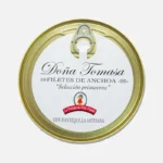 Lata de filetes de anchoa Doña Tomasa, con diseño clásico y etiqueta blanca que destaca la calidad del producto. Ideal para aperitivos y recetas gourmet.