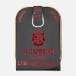 Lata de atún El Capricho, atún azul en aceite de oliva, con diseño elegante en fondo negro y texto en rojo. Ideal para recetas gourmet y platos saludables.